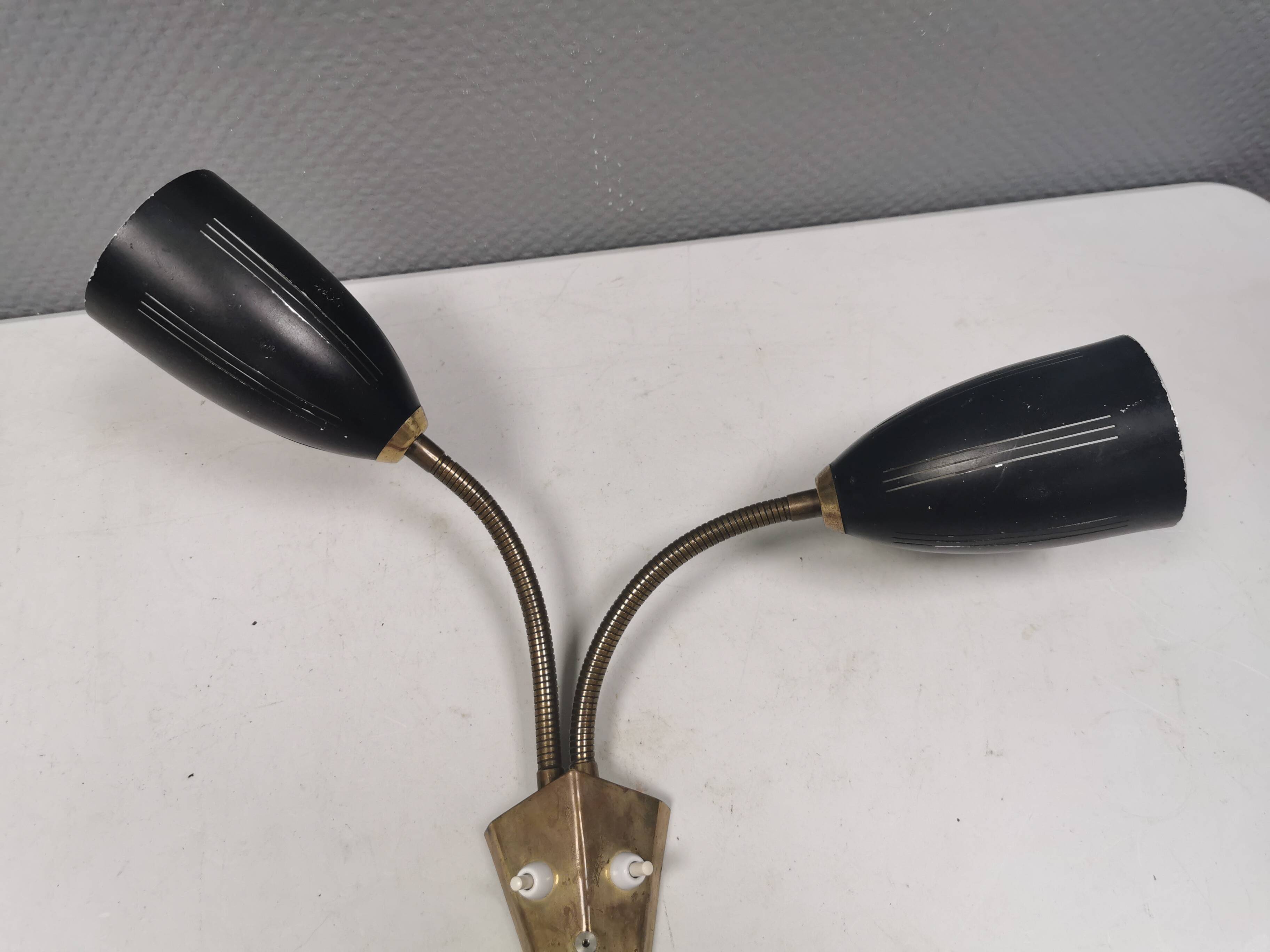Older wall lamp with black metal shades and brass bend ‘arms’