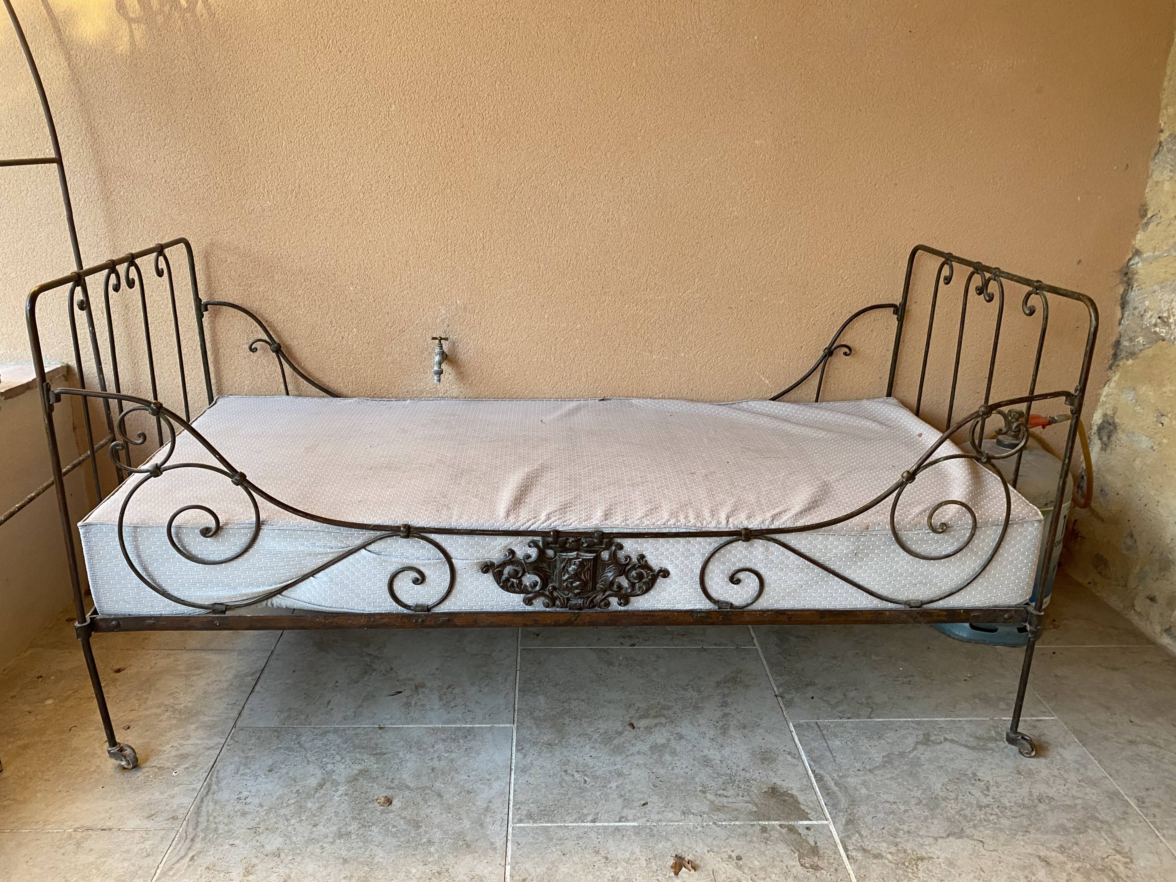 Wrought iron bed with mattress and decorative cover