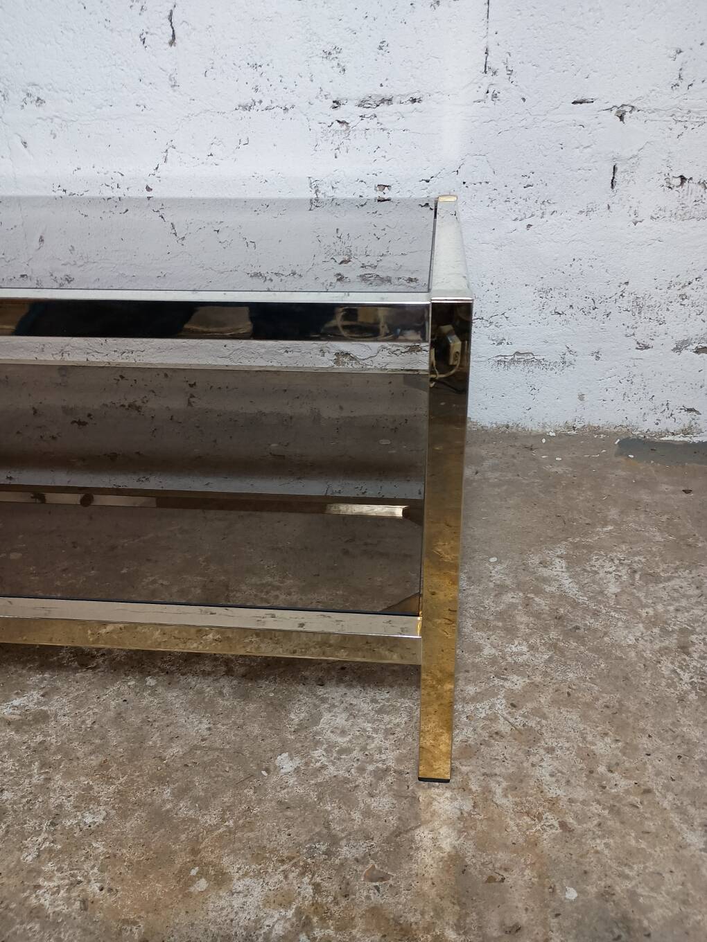 1970s coffee table in brass with a double smoked glass top.