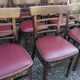 Set of 19 vintage wooden bistro chairs with red faux leather.