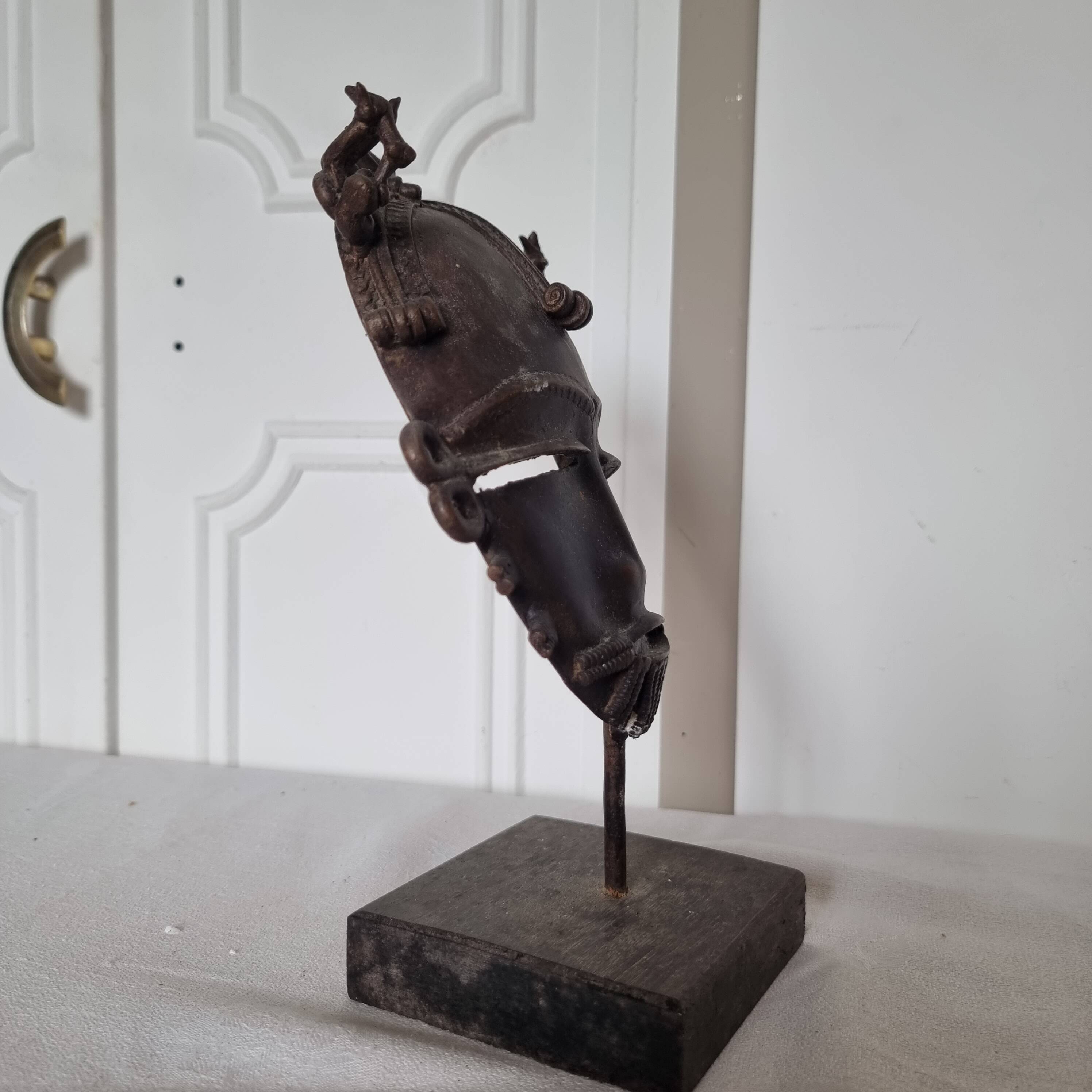 African bronze mask on pedestal, from Ivory Coast, dating