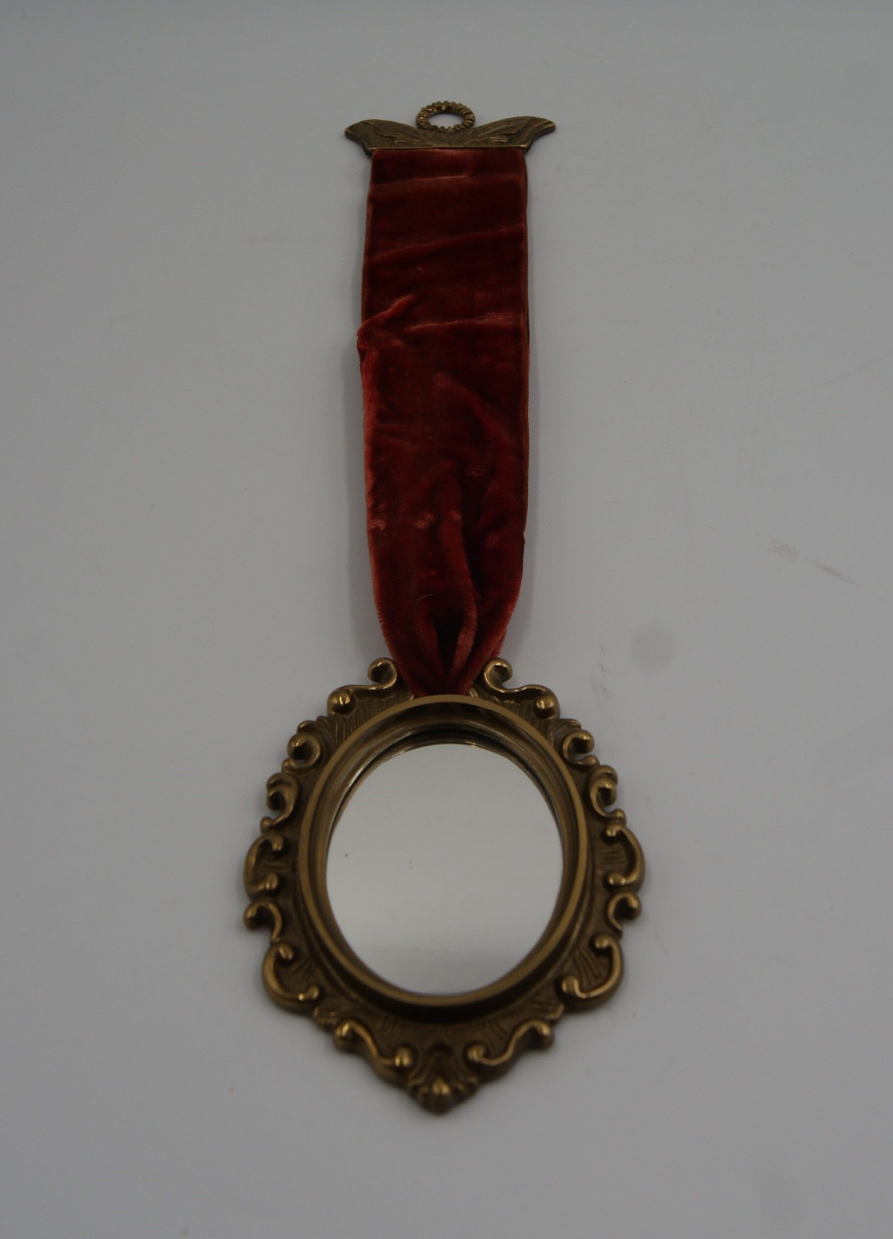 Vintage oval wall-mounted brass mirror