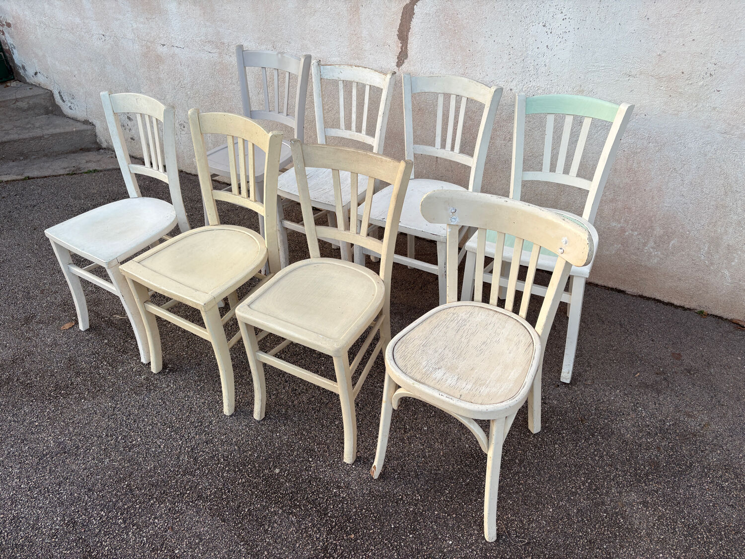 Set of 8 mismatched white bistro chairs
