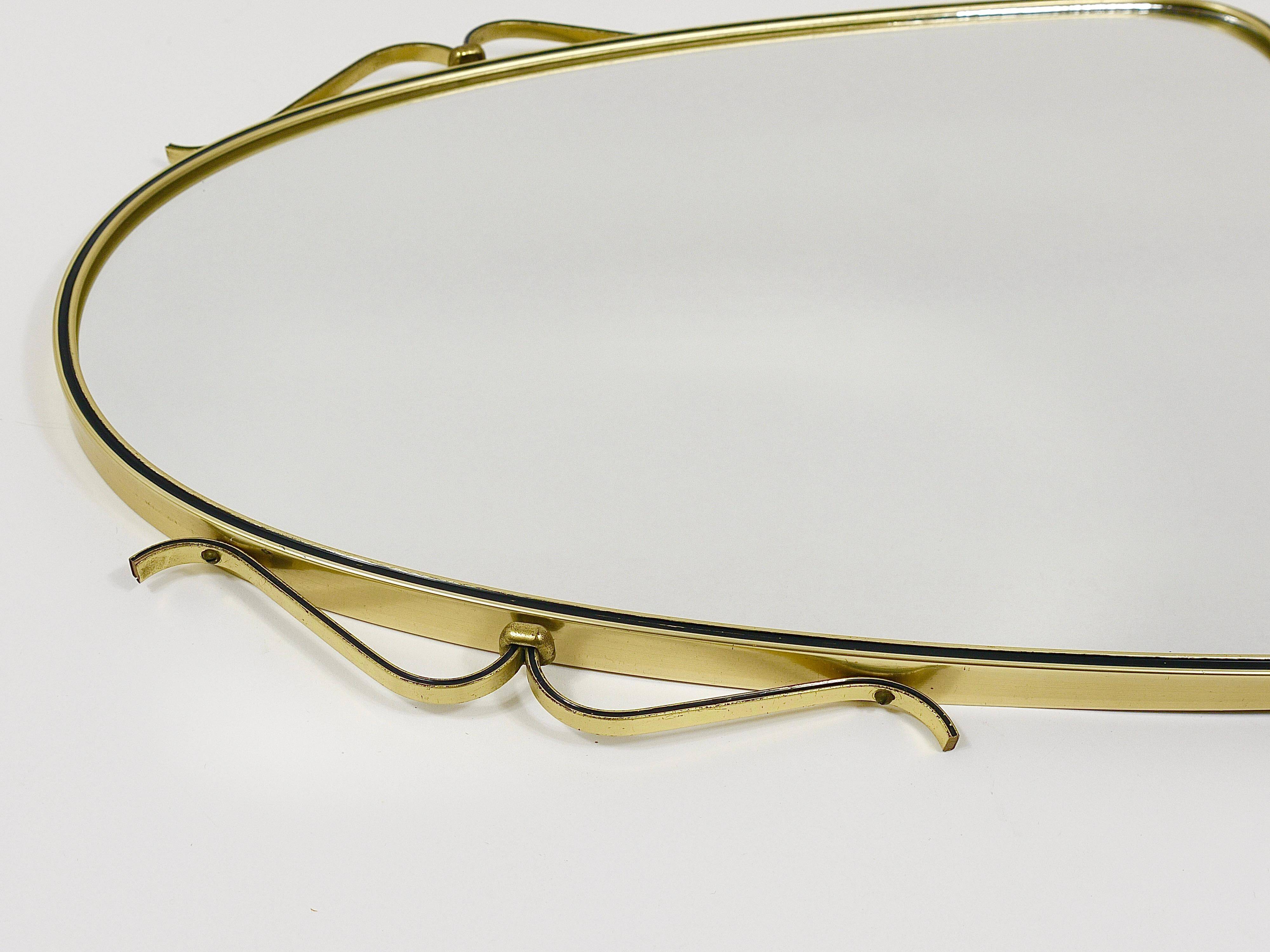 Elegant wall mirror in brass and black from the mid-century, Italy, 1950s.