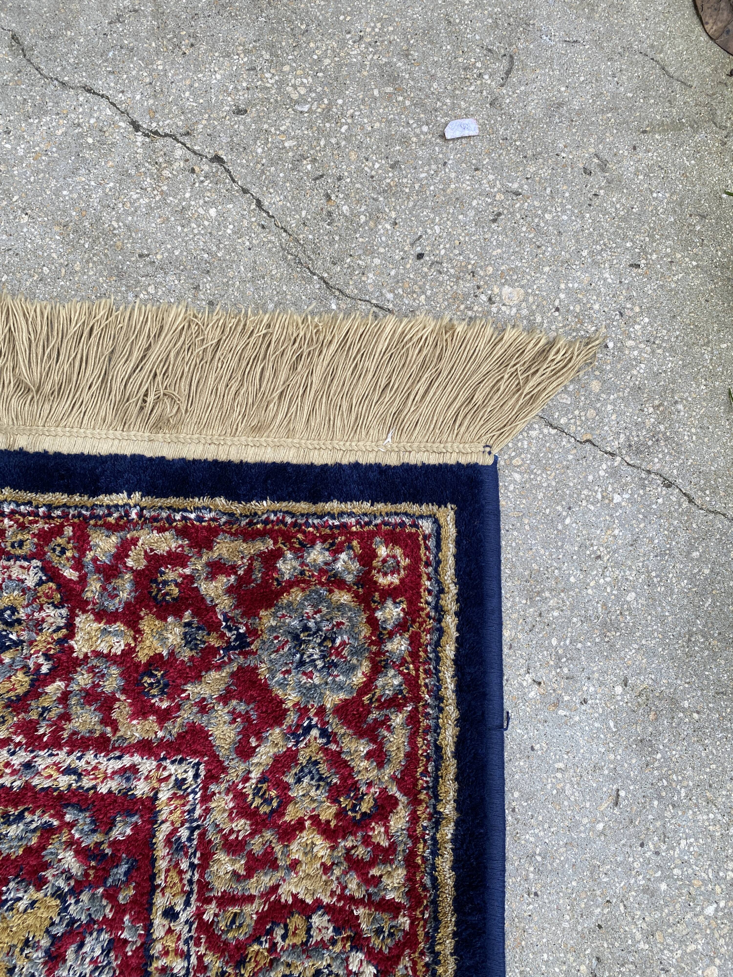 Vintage mechanical Turkish rug with box decoration on a red and navy blue background 139 x 68 cm