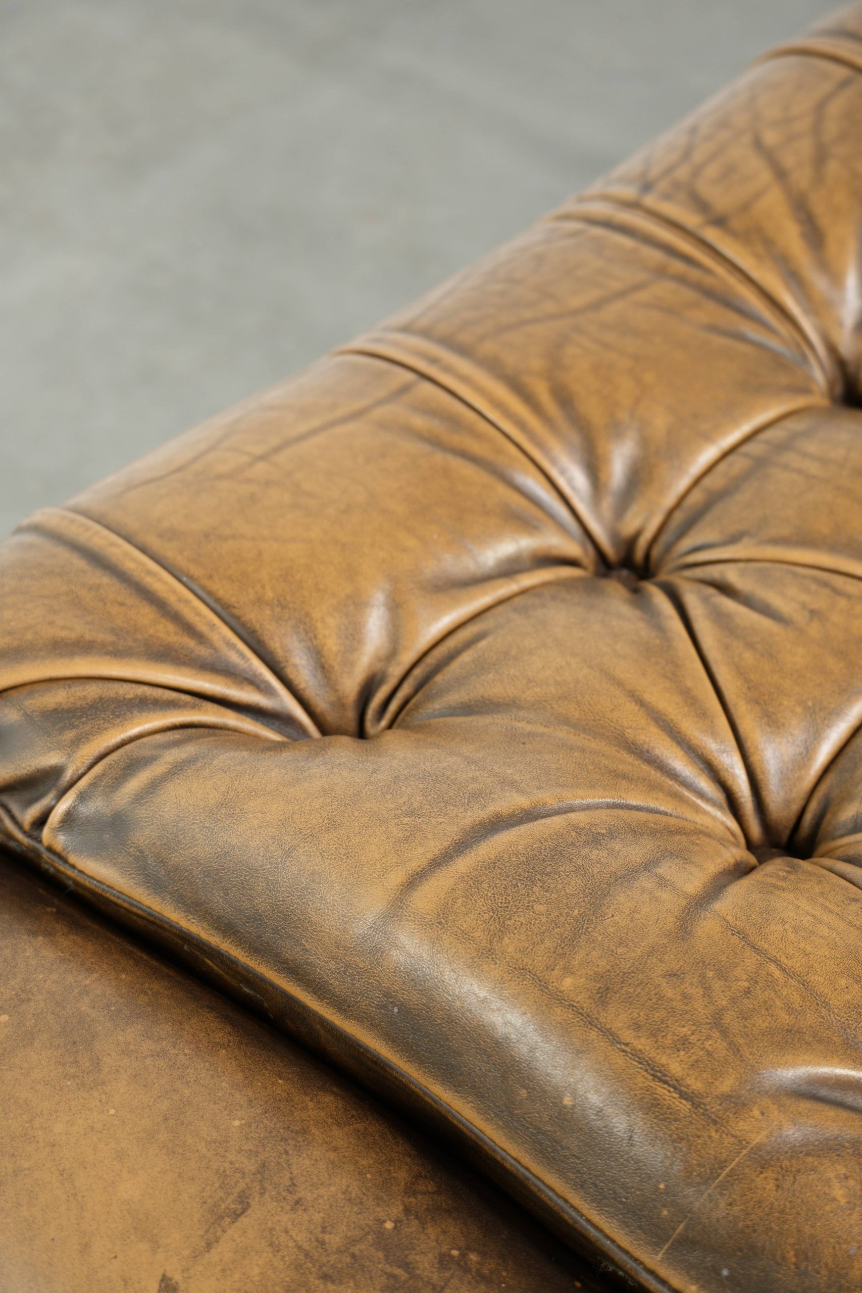 Ottoman chesterfield anglais en cuir élégant, fini avec des clous décoratifs.