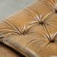 Ottoman chesterfield anglais en cuir élégant, fini avec des clous décoratifs.