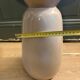 Large beige ceramic table lamp with a vintage shade.