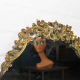 Miroir mural ovale antique dans un cadre en laiton avec ornement supérieur