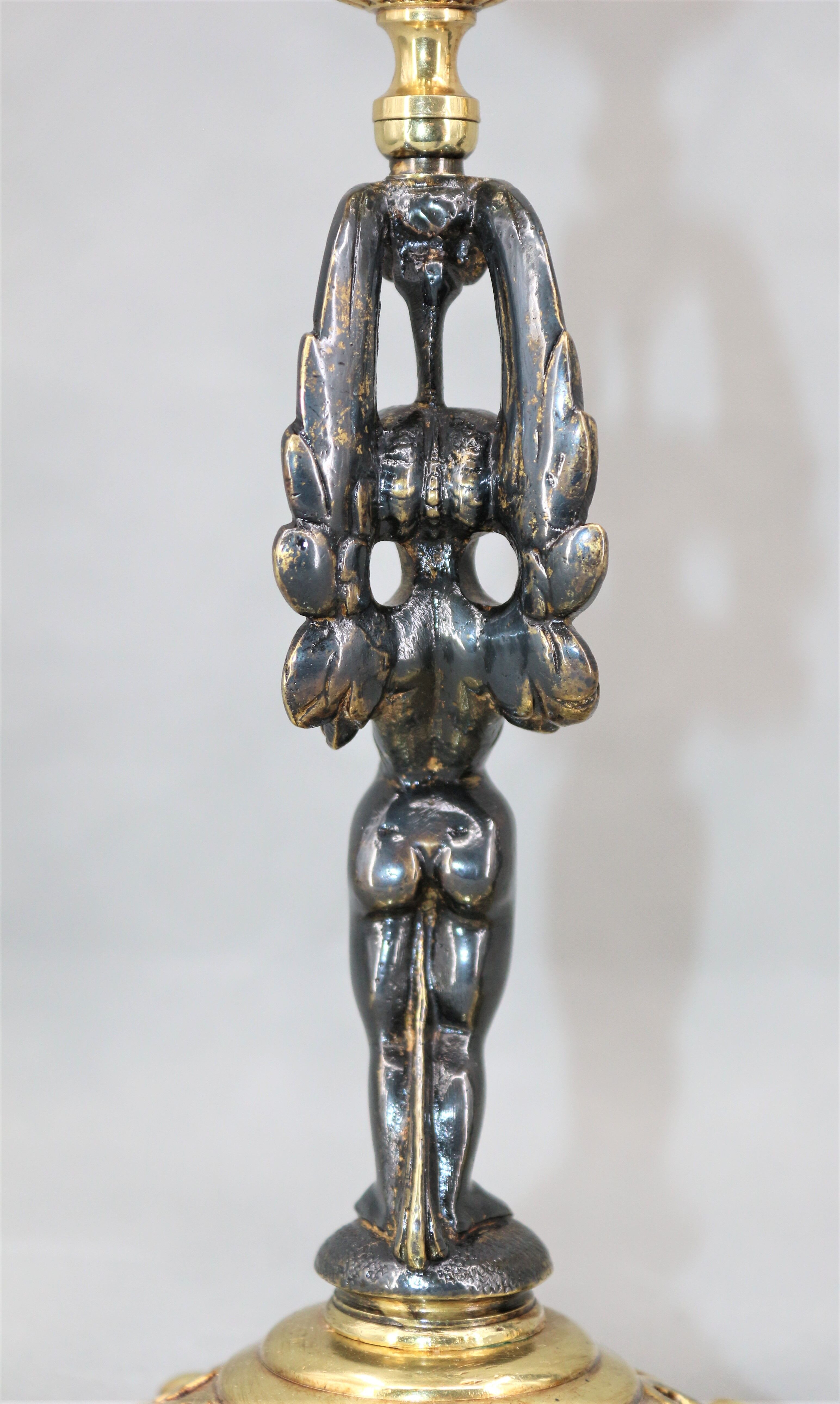 Pair of candle holders in gilded bronze and patinated with a candle