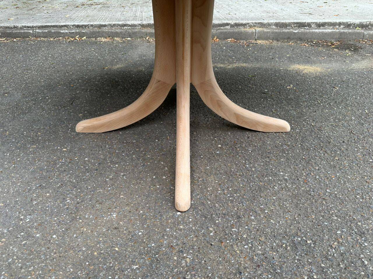 Renovated oval Scandinavian extendable dining table in wood with a central leg.