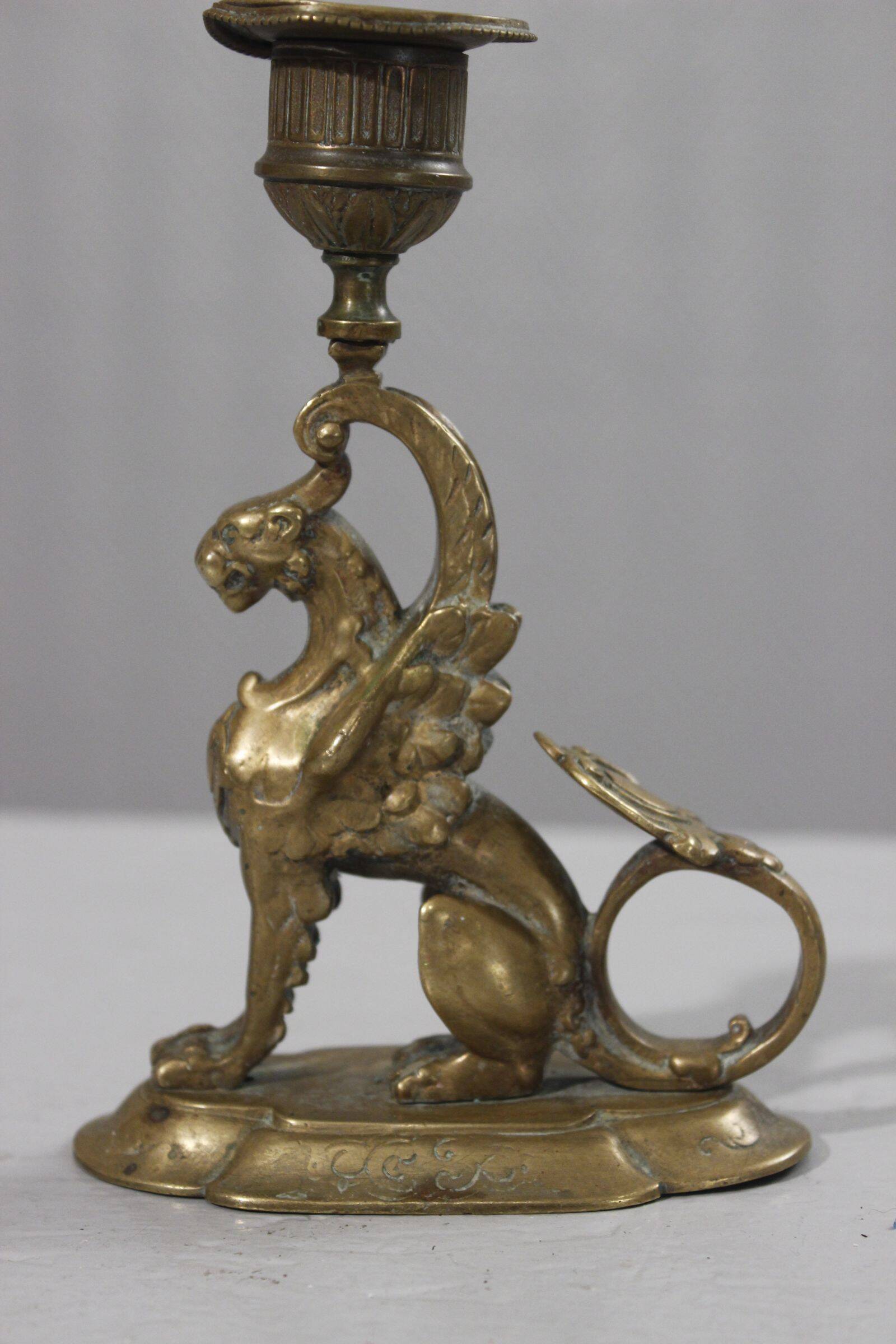 Handheld candlestick in bronze featuring a griffin, 19th-century Empire style.