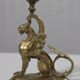 Handheld candlestick in bronze featuring a griffin, 19th-century Empire style.