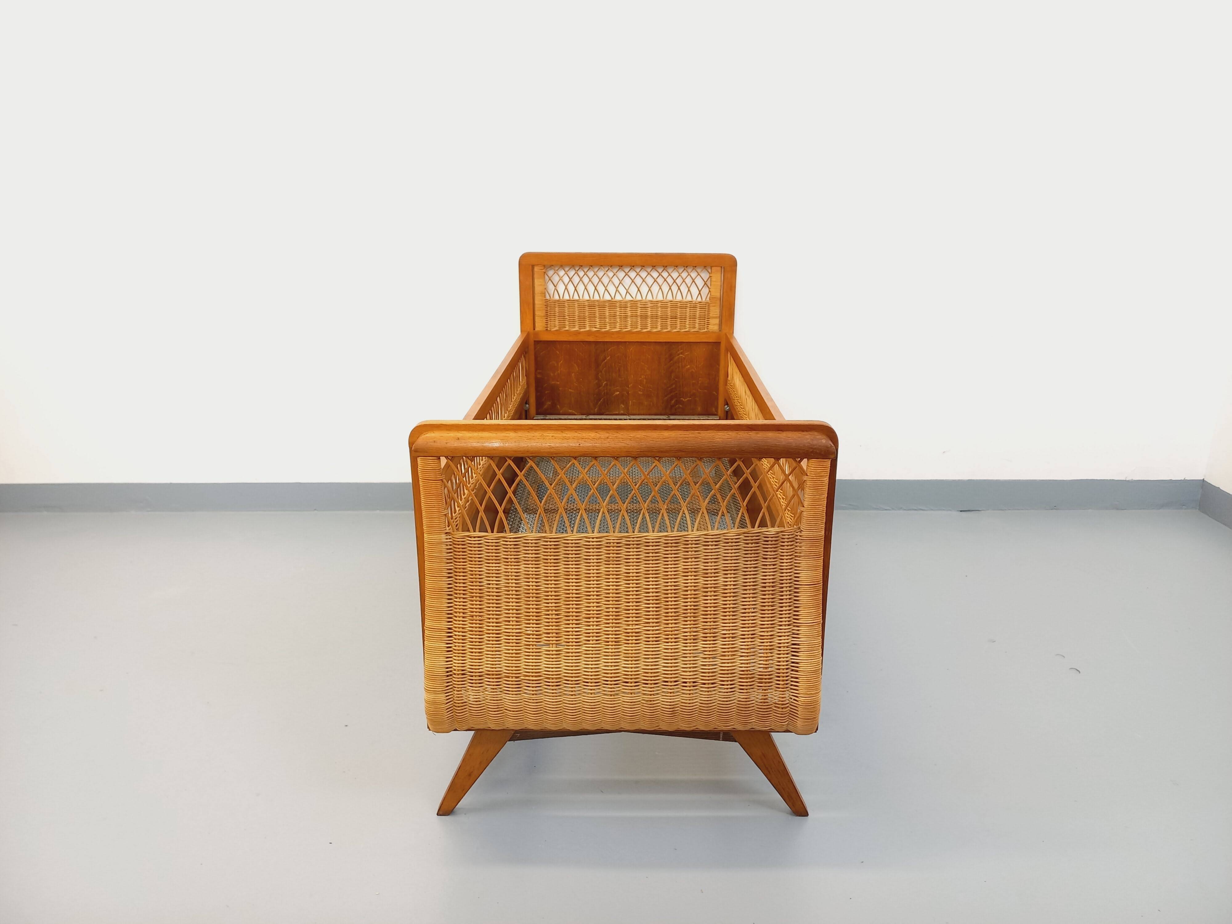 Vintage oak and rattan baby cot from the 1960s.
