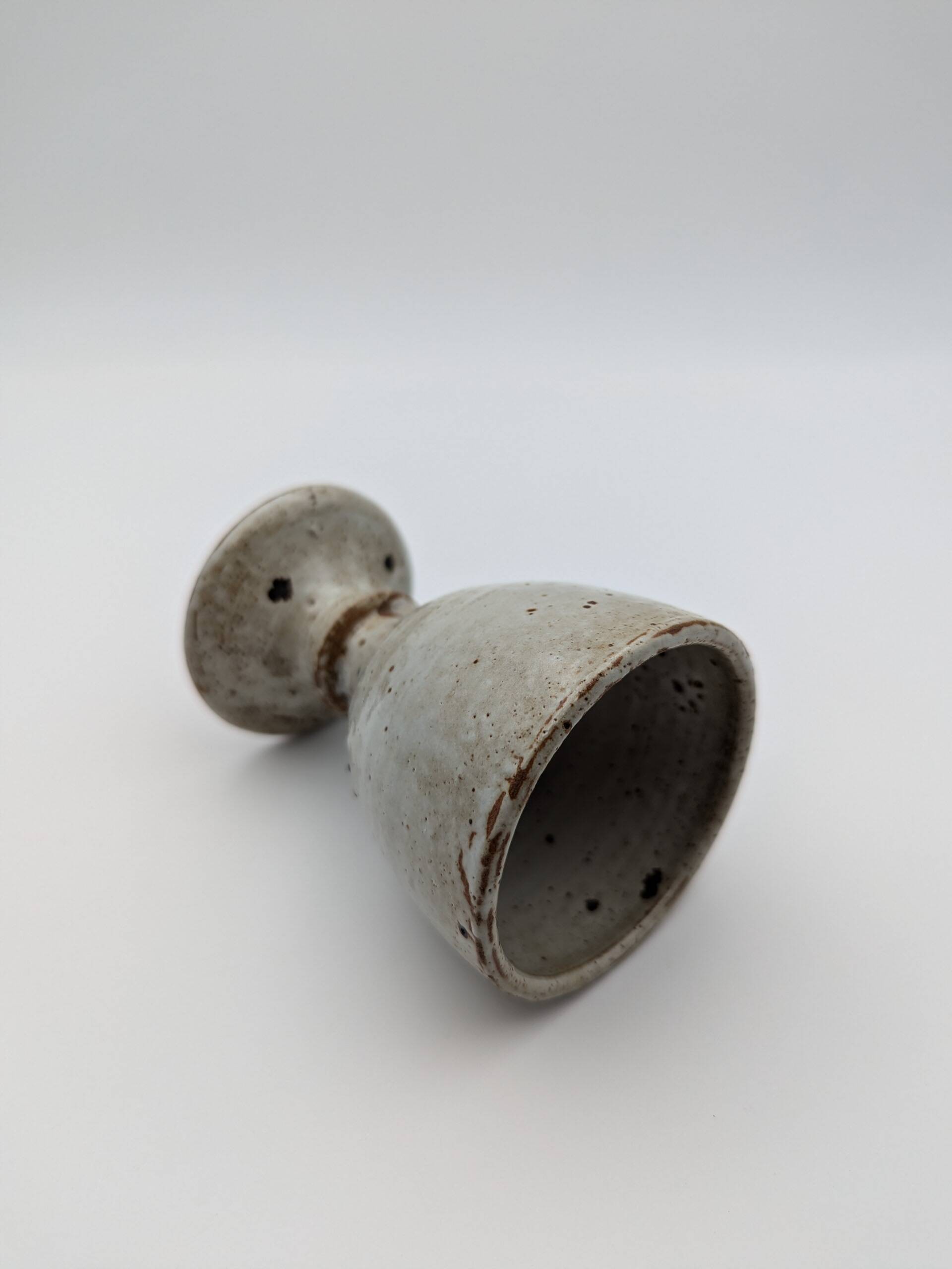 Glass on foot in pearly white stoneware with black spots