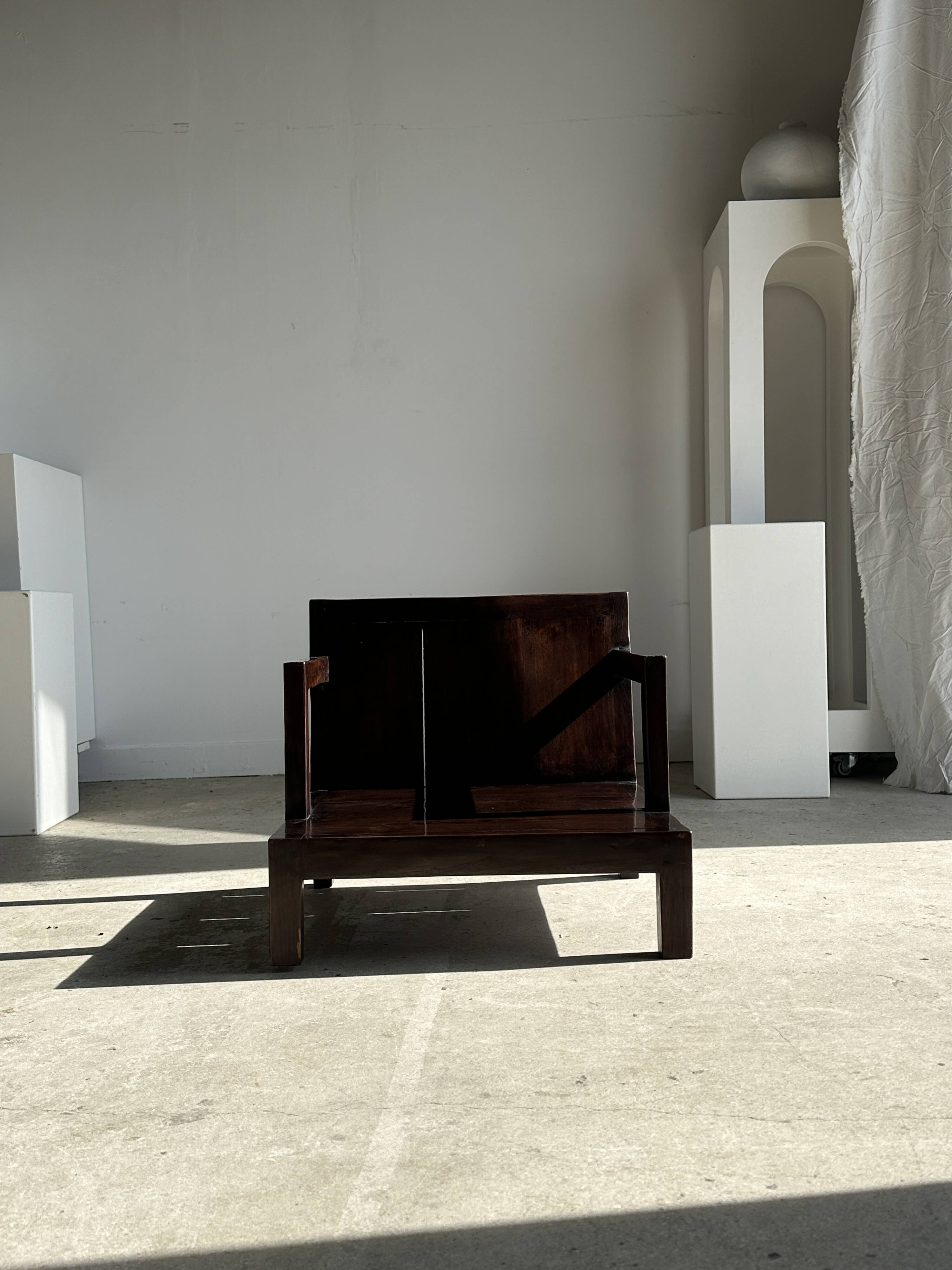 Small low armchair in varnished brown wood