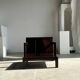 Small low armchair in varnished brown wood