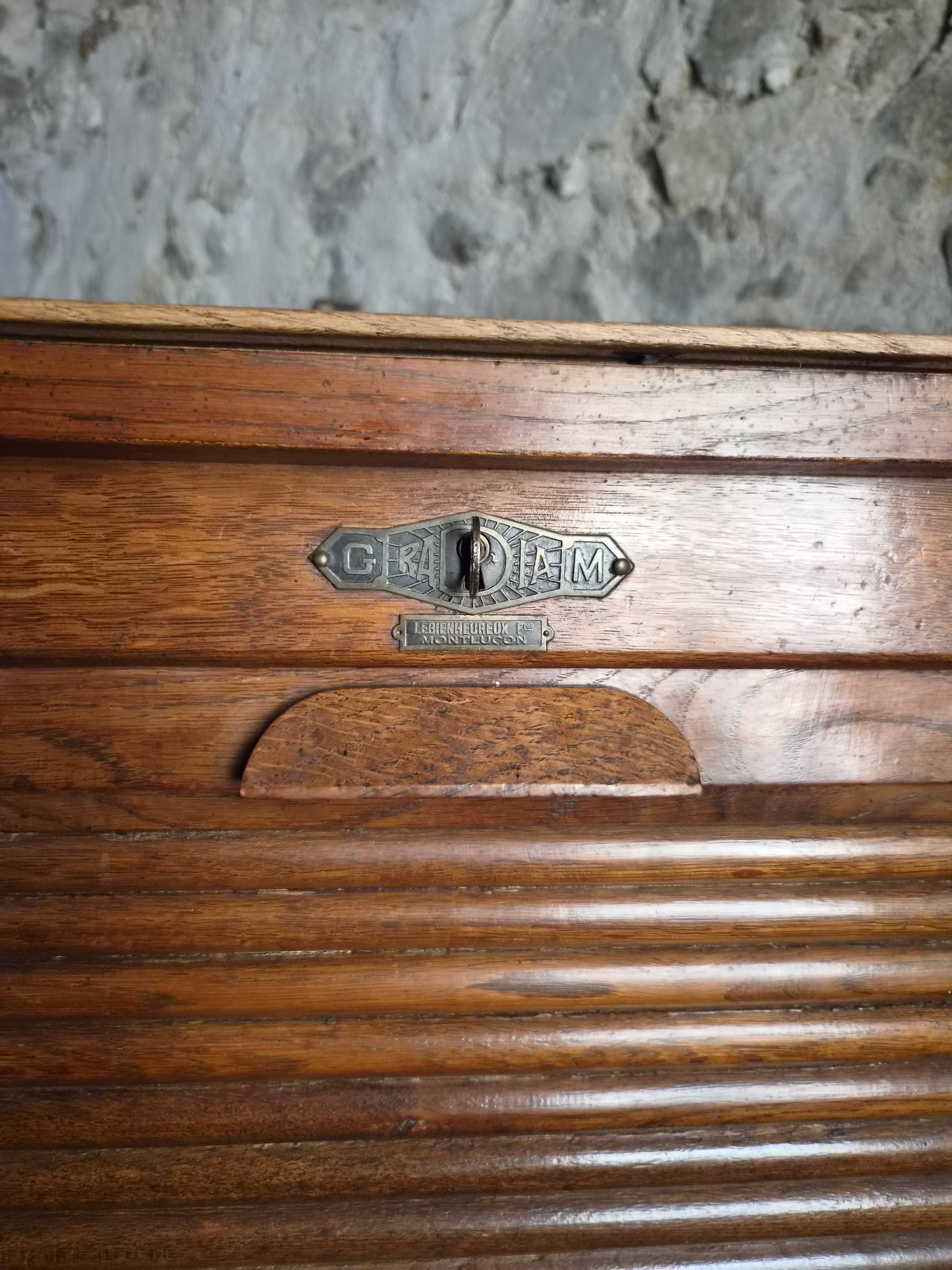 French antique wardrobe with curtain in oak, circa 1920–1930.