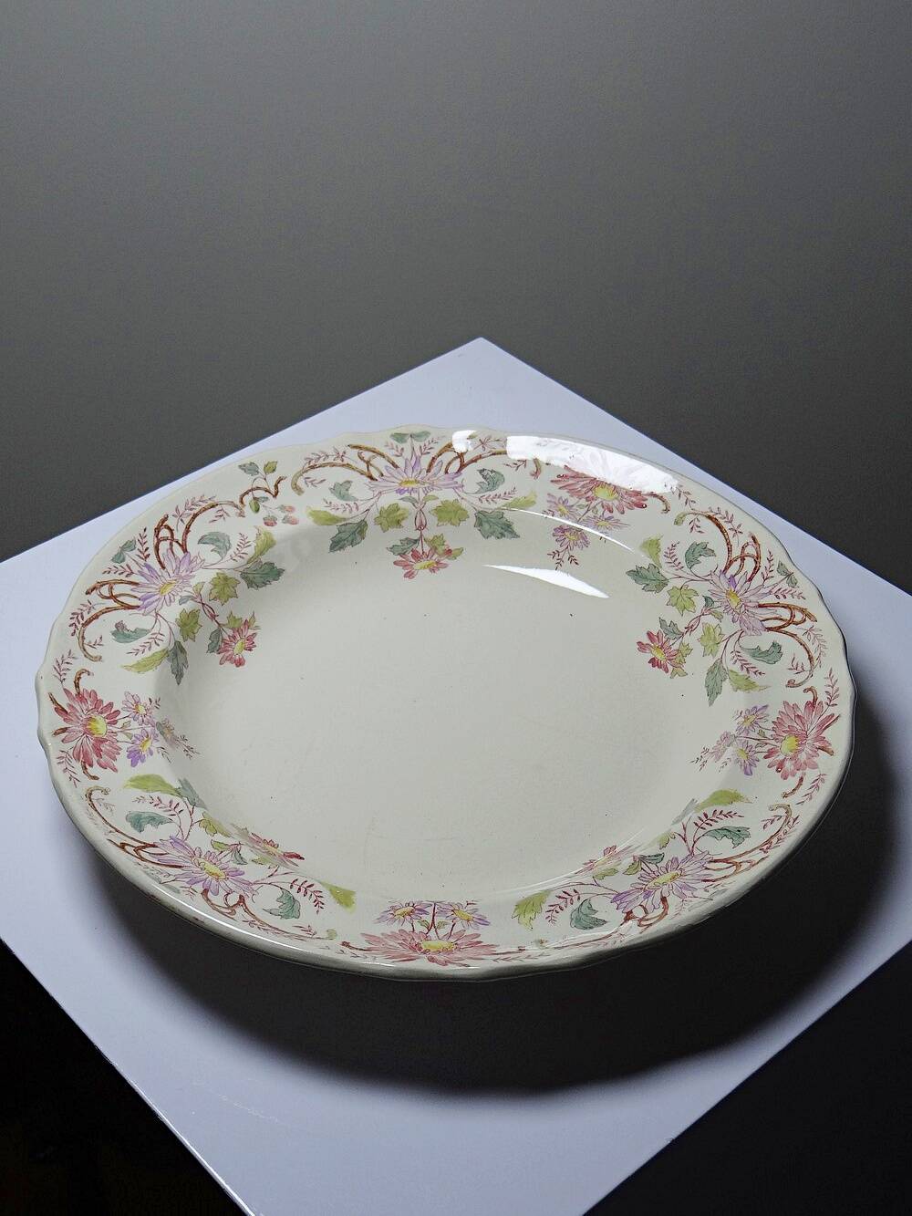 Antique Longchamp service shallow dish with polychrome daisies, ironstone, 19th century.
