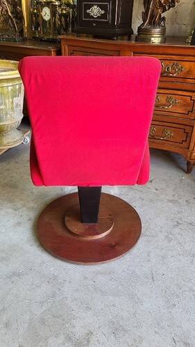 Old cinema chair with a red reclining seat.