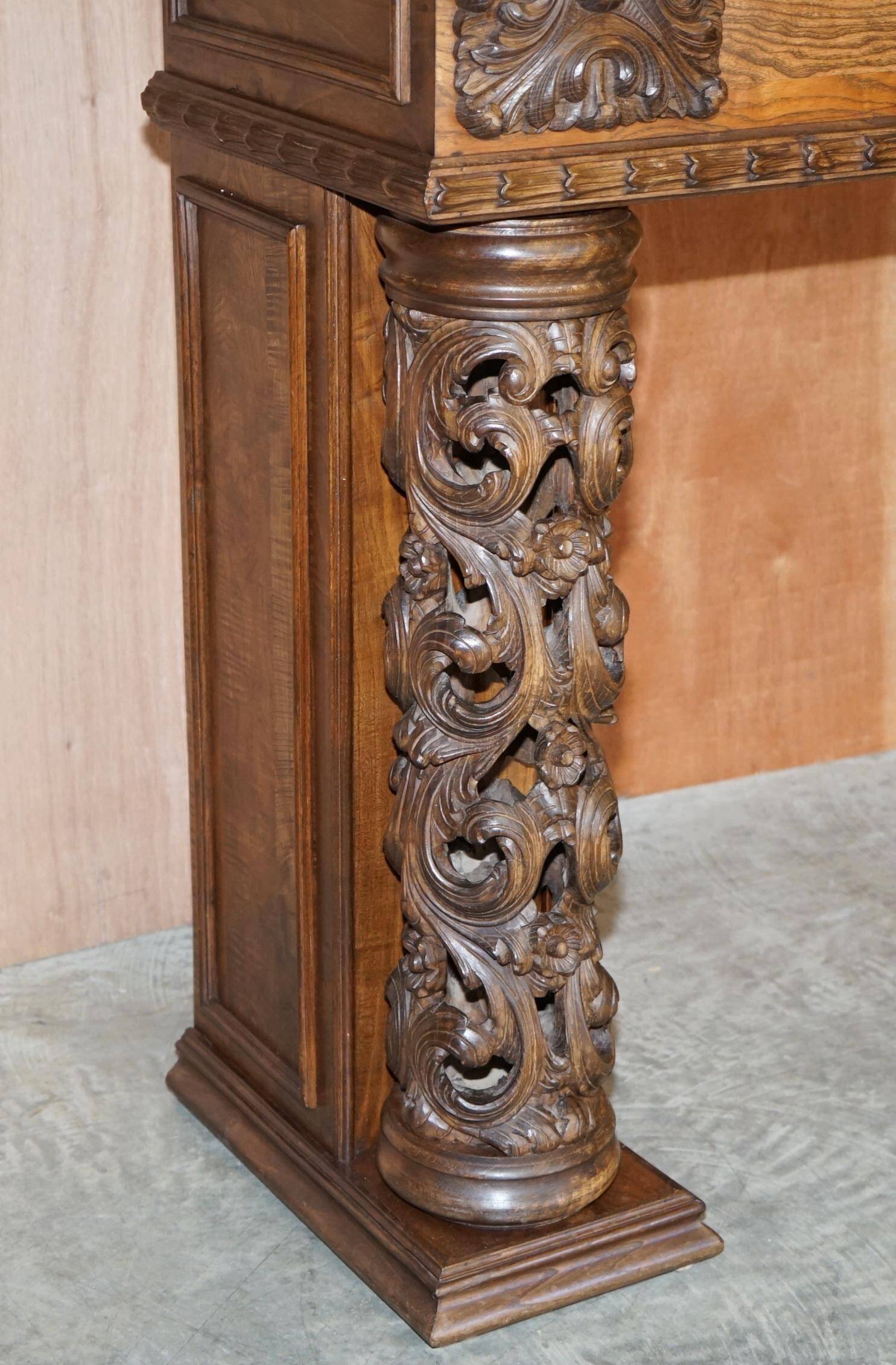 Antique fireplace from around 1880 in solid hand-carved elm with openwork columns.