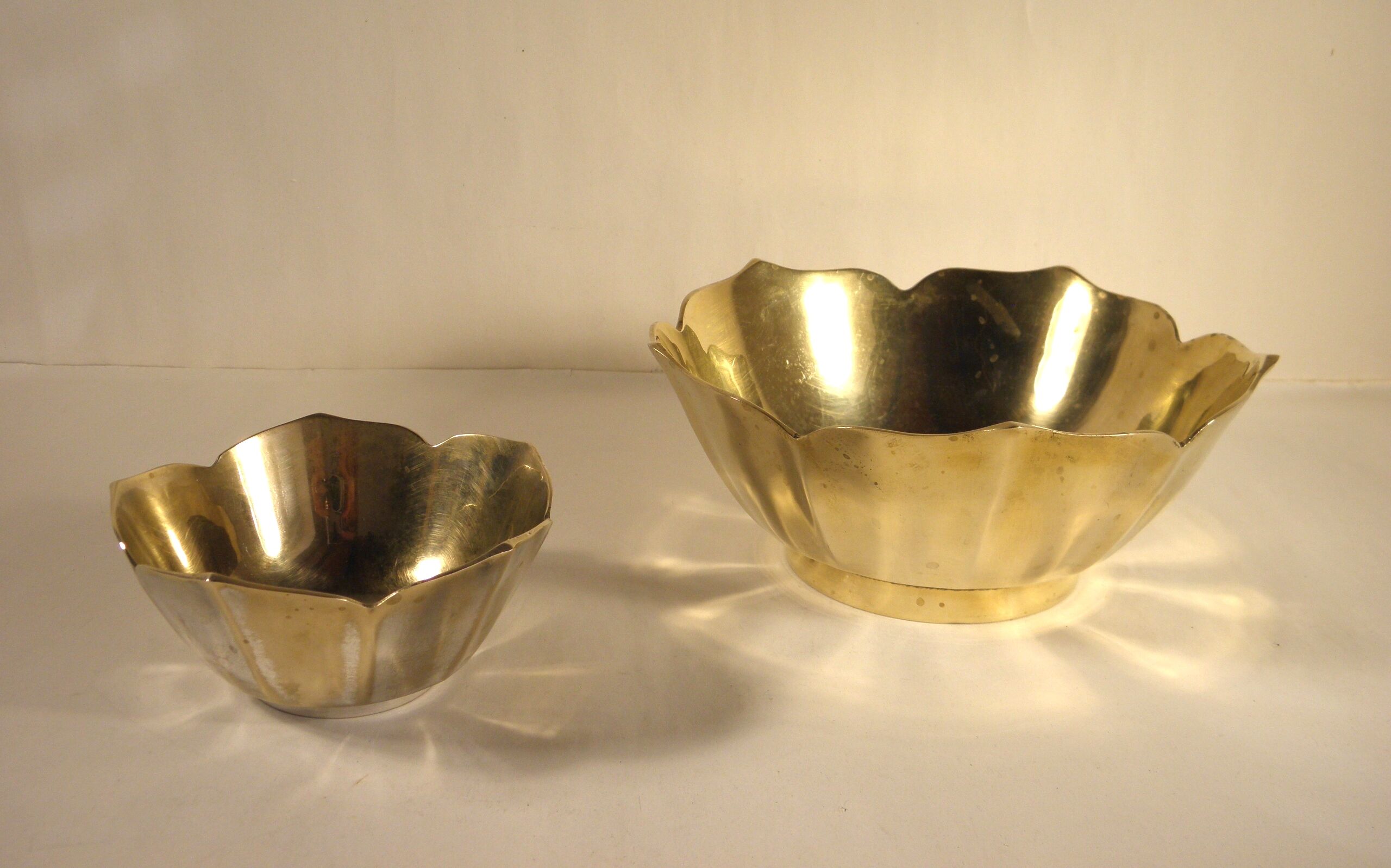 Two brass trundle cups