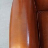 Correct, comfortable, luxurious English-style wingback armchair made of cognac-colored cow leather