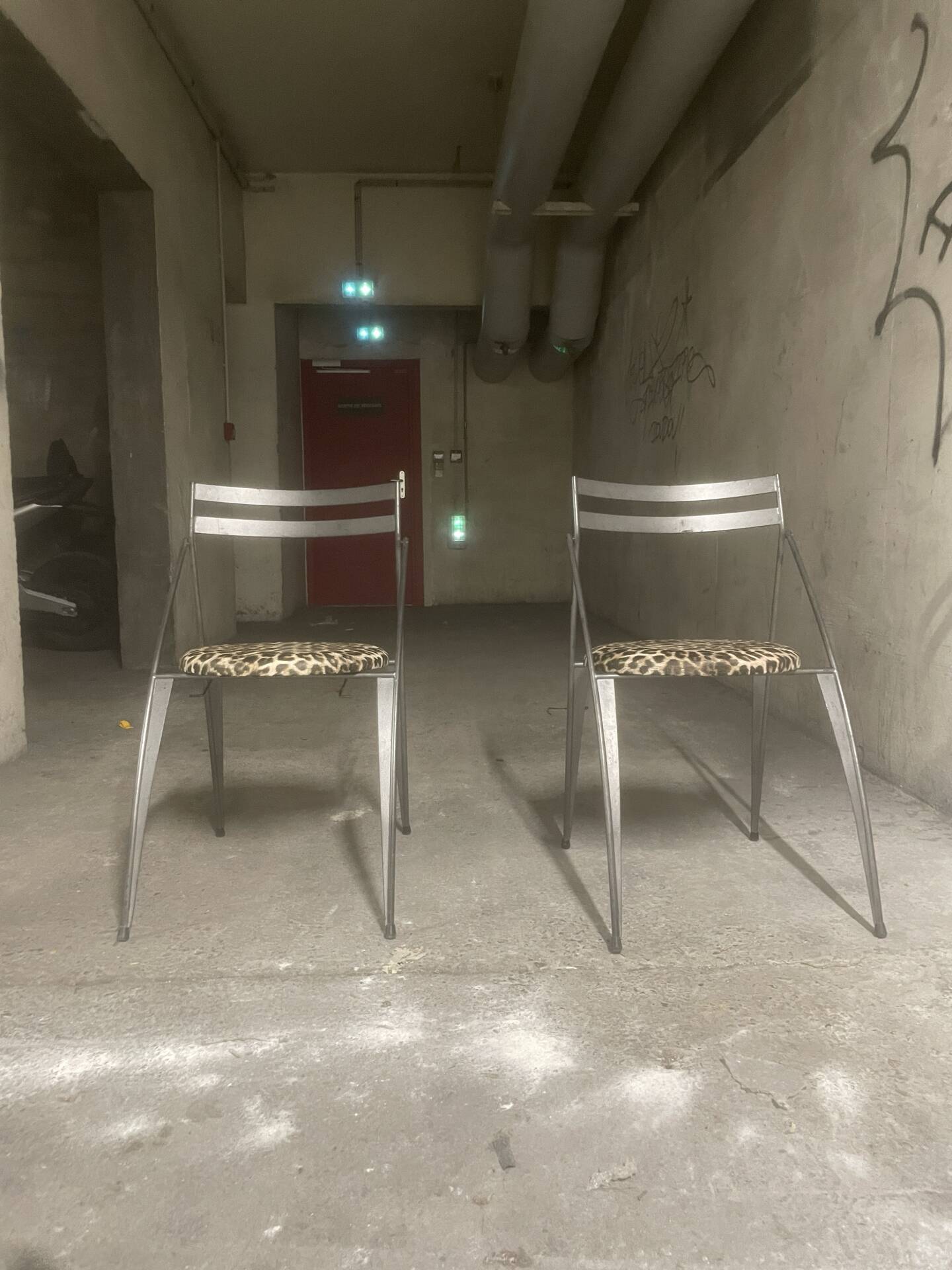 Pair of folding chairs from the 80s with leopard print seats.