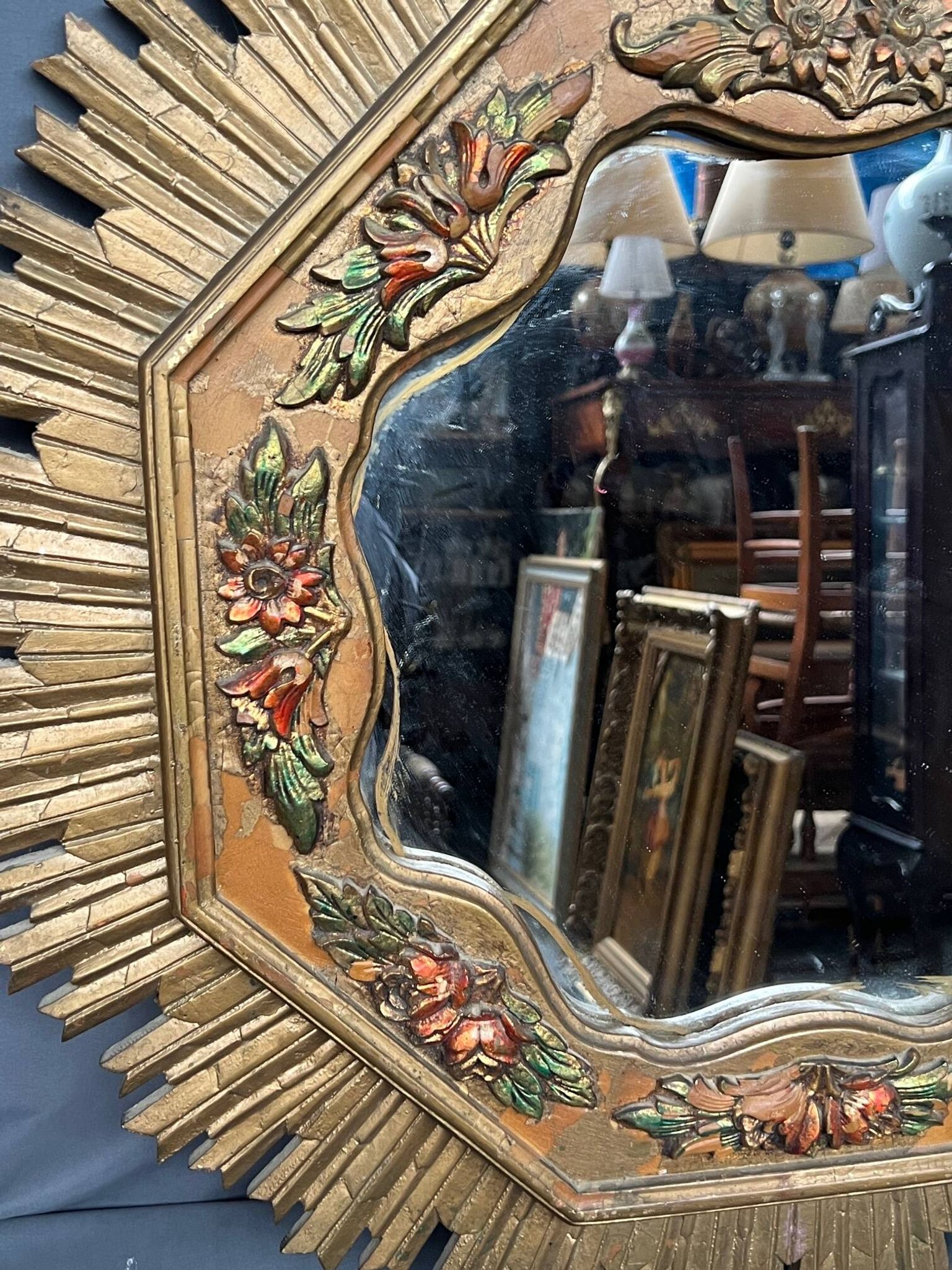 Large wooden mirror with golden sun rays, in Art Deco style.