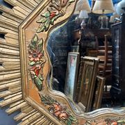 Large wooden mirror with golden sun rays, in Art Deco style.