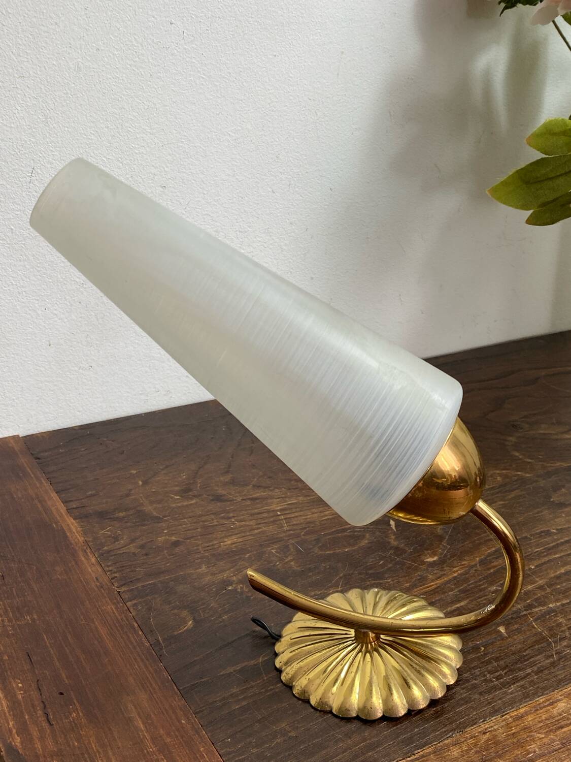 Gold metal wall light with ribbed glass.
