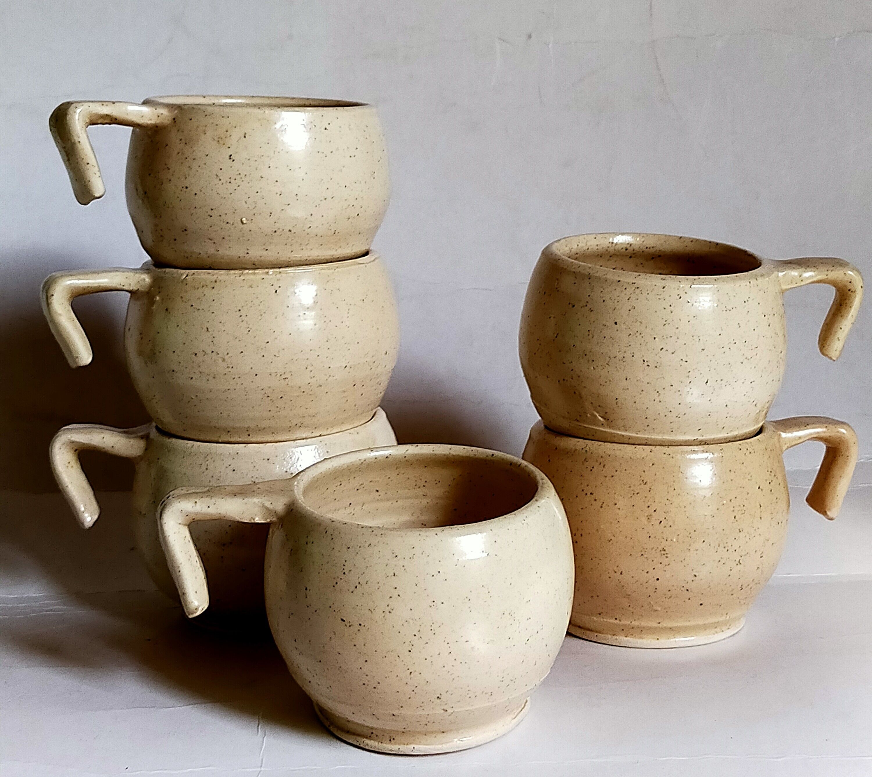 Six vintage potter's ceramic cups with vanilla enamel