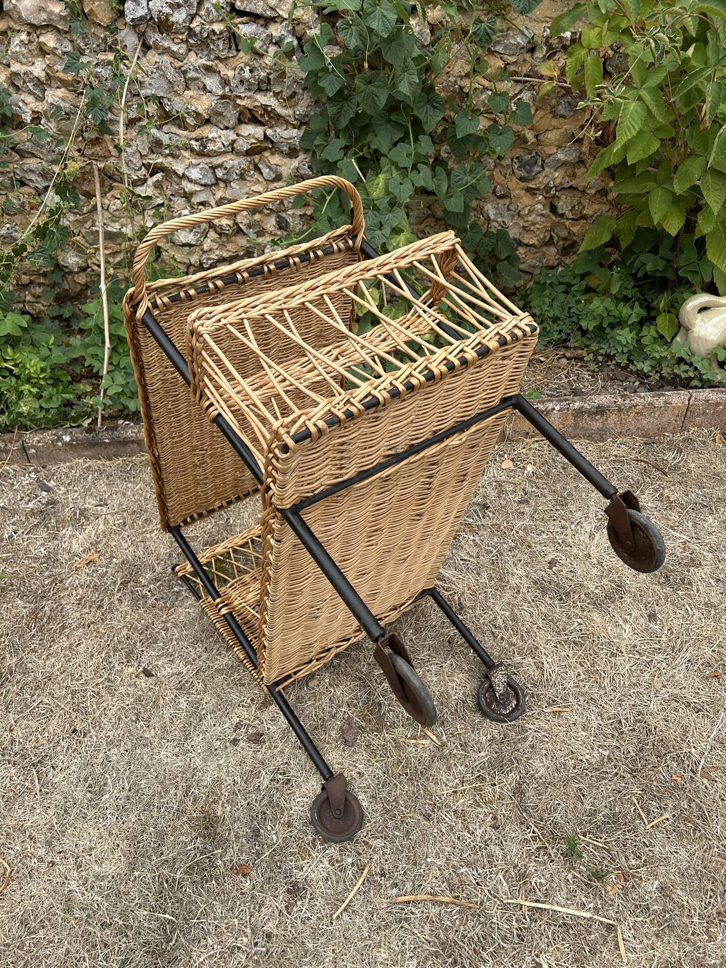 Vintage 1950s rolling dessert trolley in wicker and black tubing.