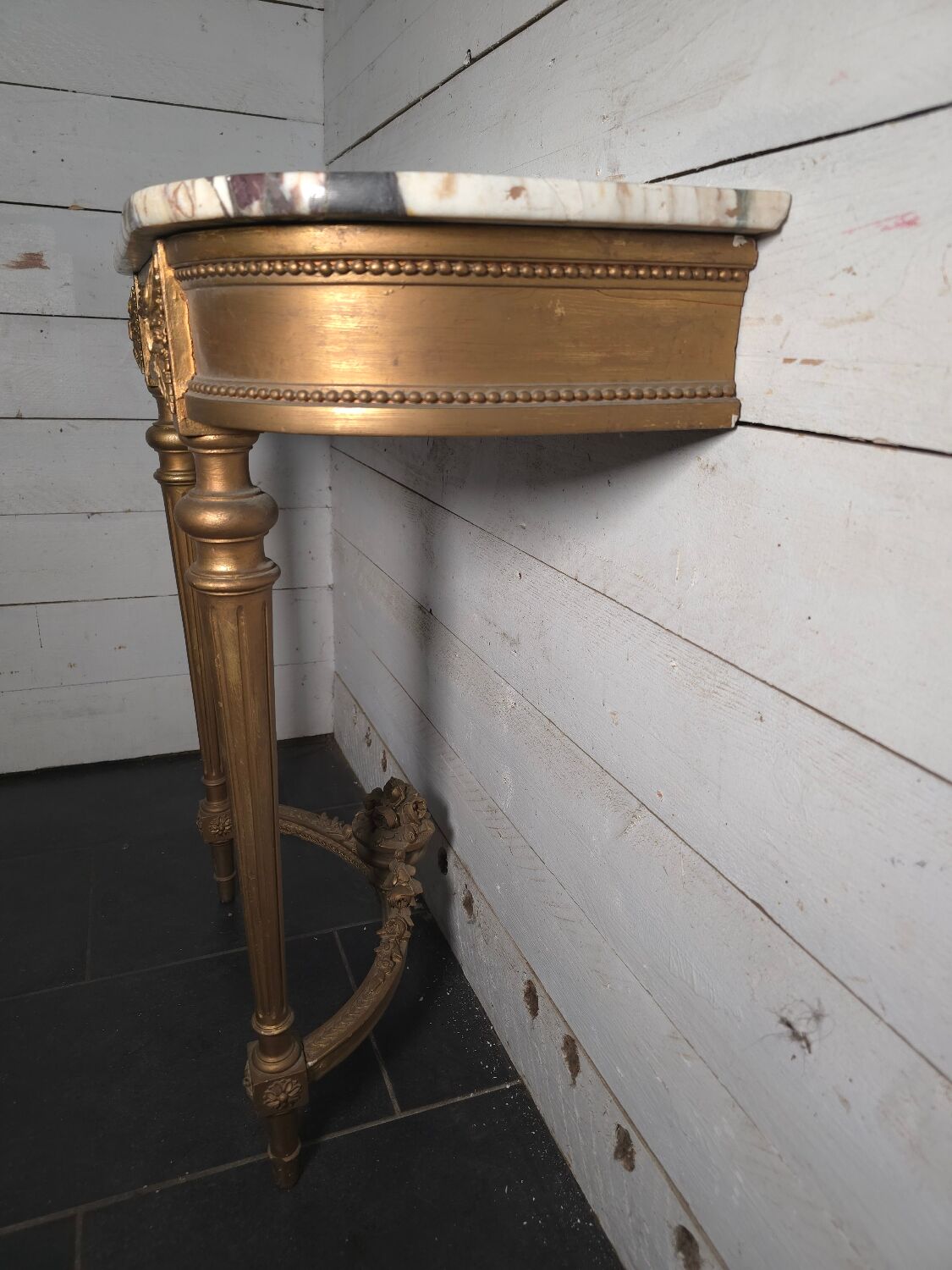 Louis XVI style console in gilded wood with a marble top.