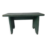 Old small wooden bench with green foot