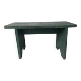 Old small wooden bench with green foot