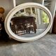 Oval mirror in pearl-coloured stucco 85 x 114 cm