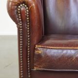 Comfortable, rugged cognac-colored sheepskin club armchair with a characteristic seat cushion