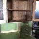 Vintage wooden kitchen cupboard painted green and beige, with glass doors - 1930s
