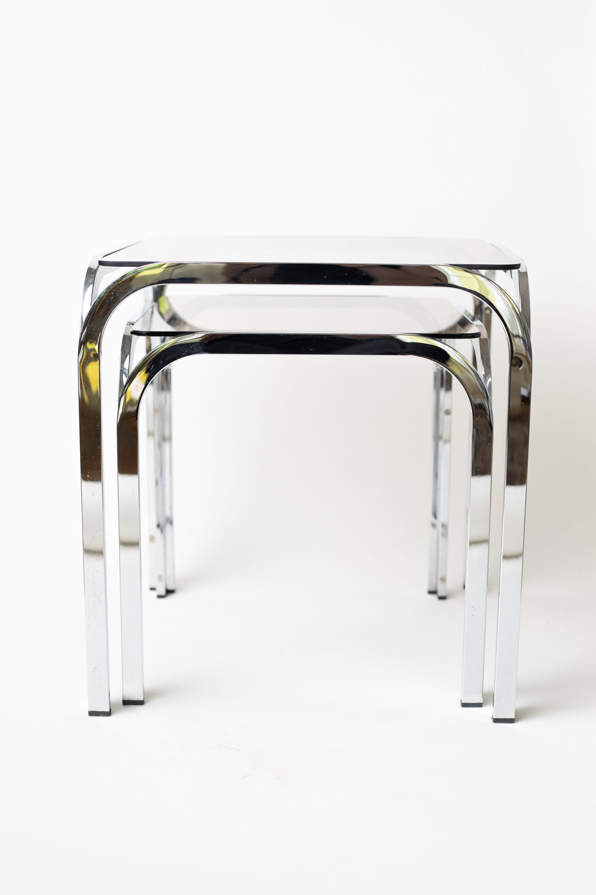 Pair of chrome nesting tables with smoked glass tops