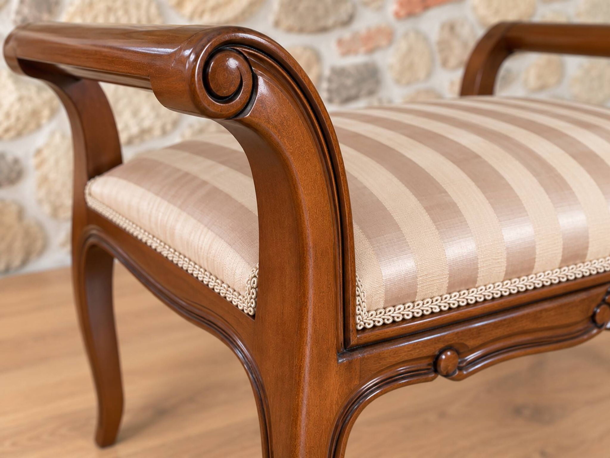 Two-seater bench in carved wood, with curved armrests.