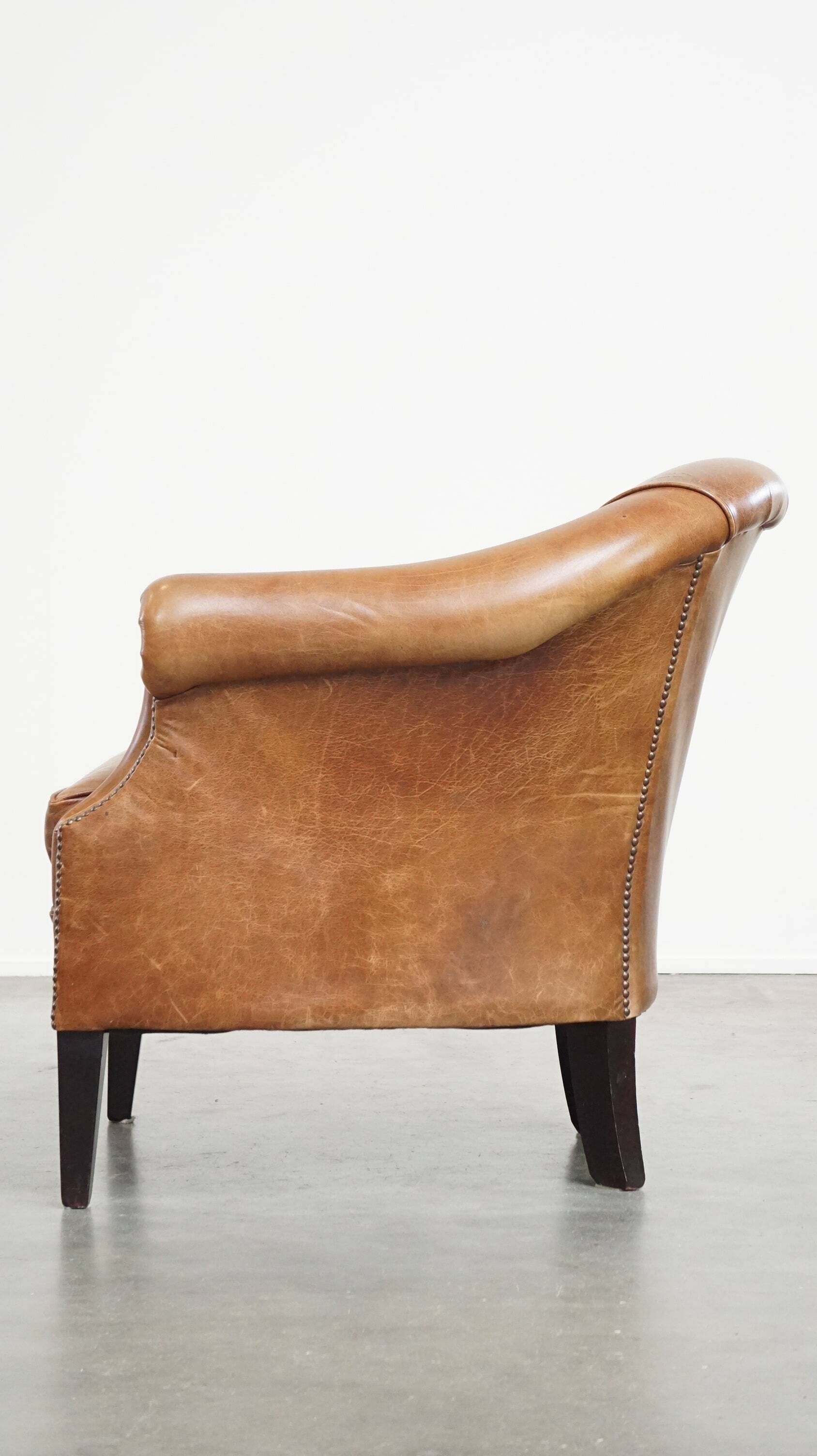 Very comfortable, elegant leather club armchair with a removable seat cushion and timeless design