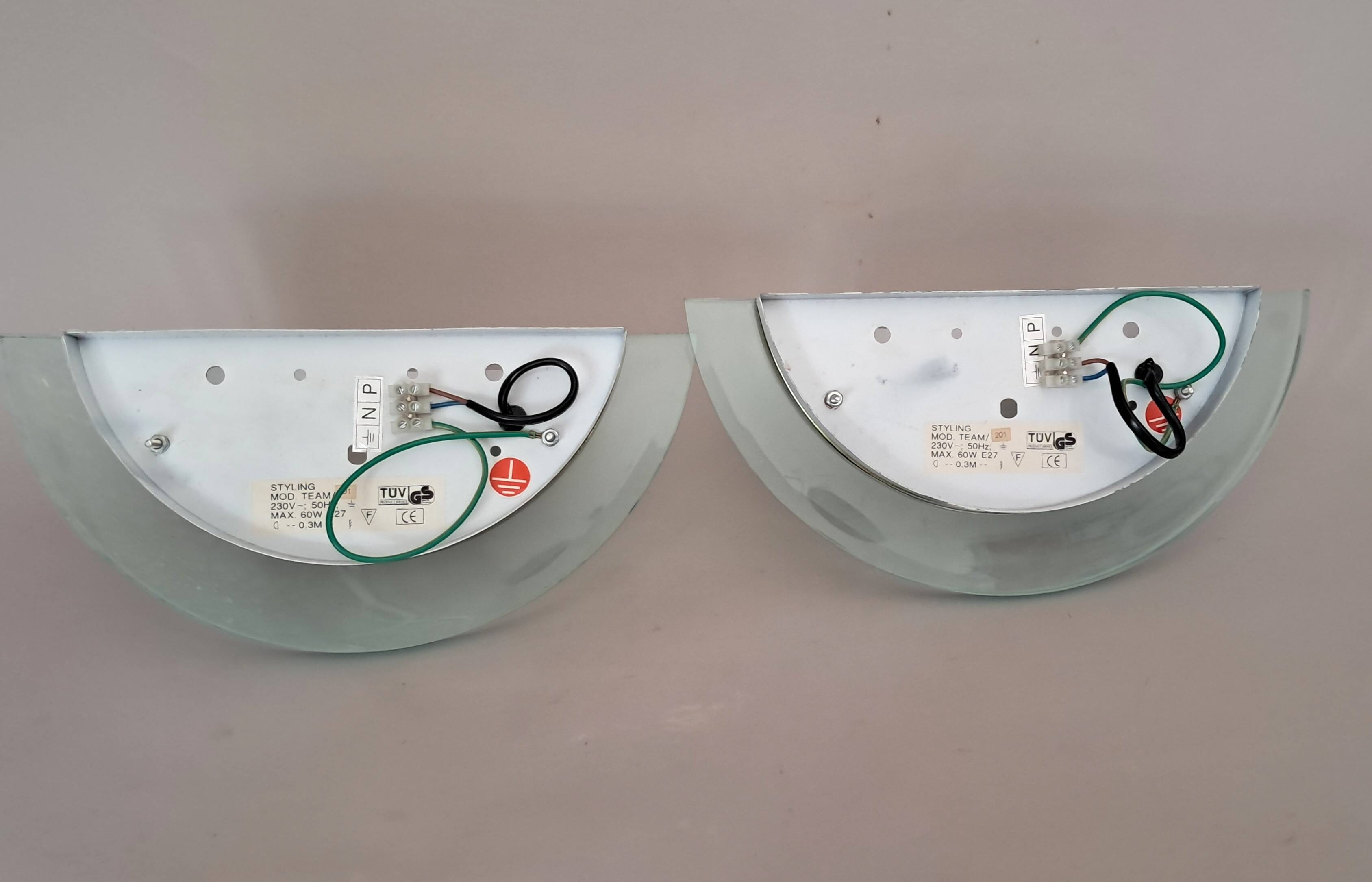 Pair of gold metal and plexiglass wall lights, circa 1980.