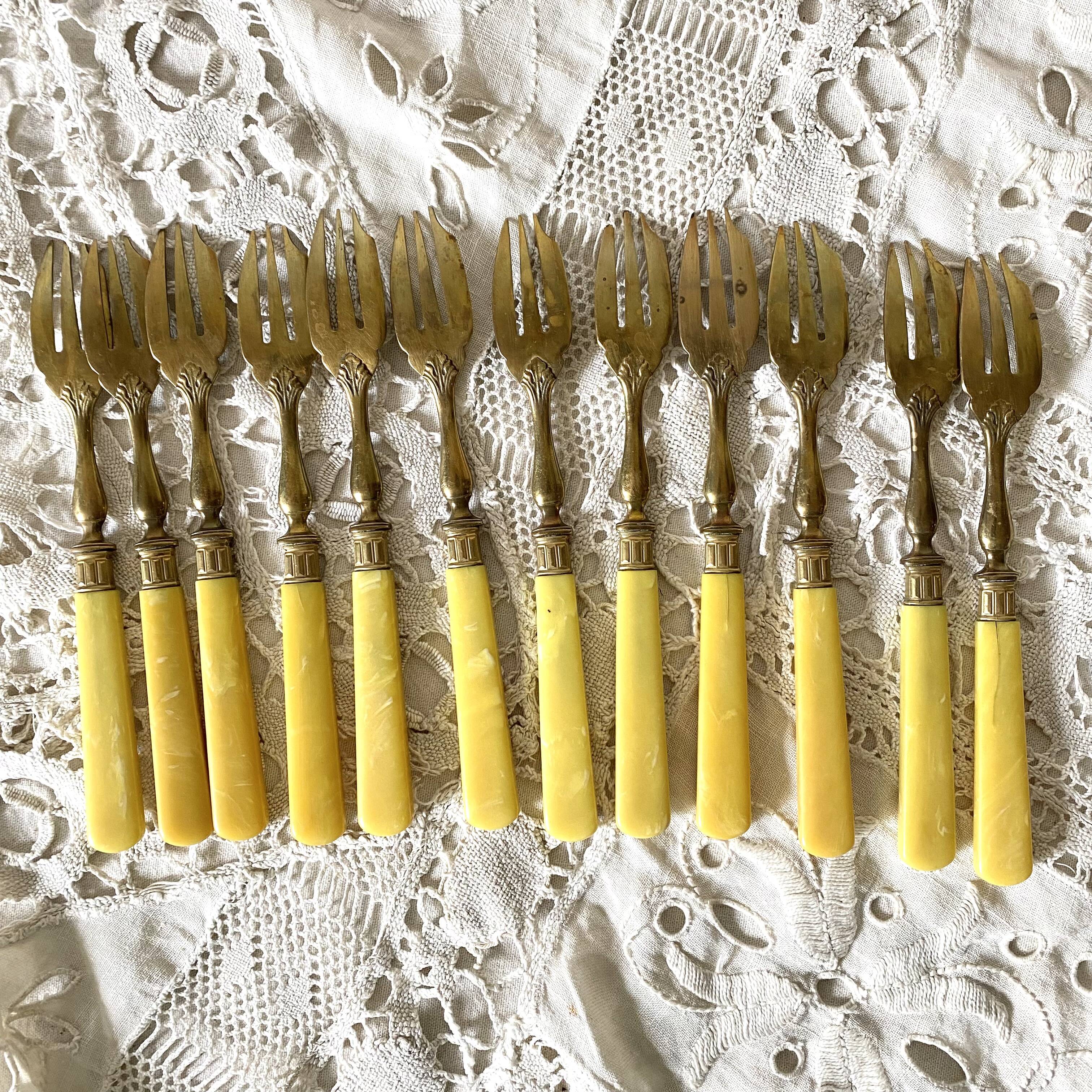 Antique dessert forks in brass and bakelite