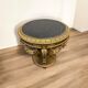 A round Louis XV style table in carved gilt beechwood with a black marble top