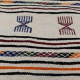 White carpet with multicolored Berber patterns woven hands