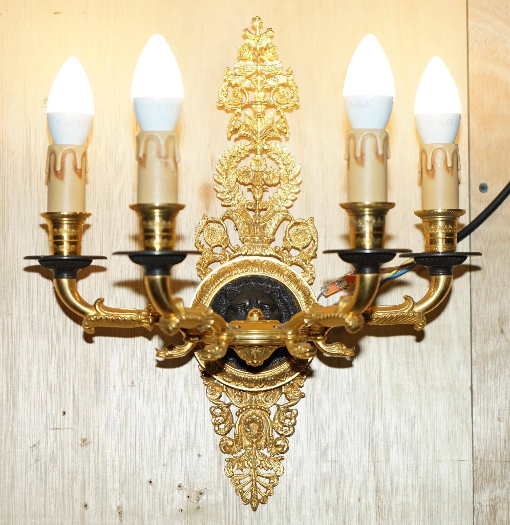 Pair of L'Originale wall sconces plated with 24-carat gold featuring four bronze candles.