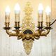 Pair of L'Originale wall sconces plated with 24-carat gold featuring four bronze candles.