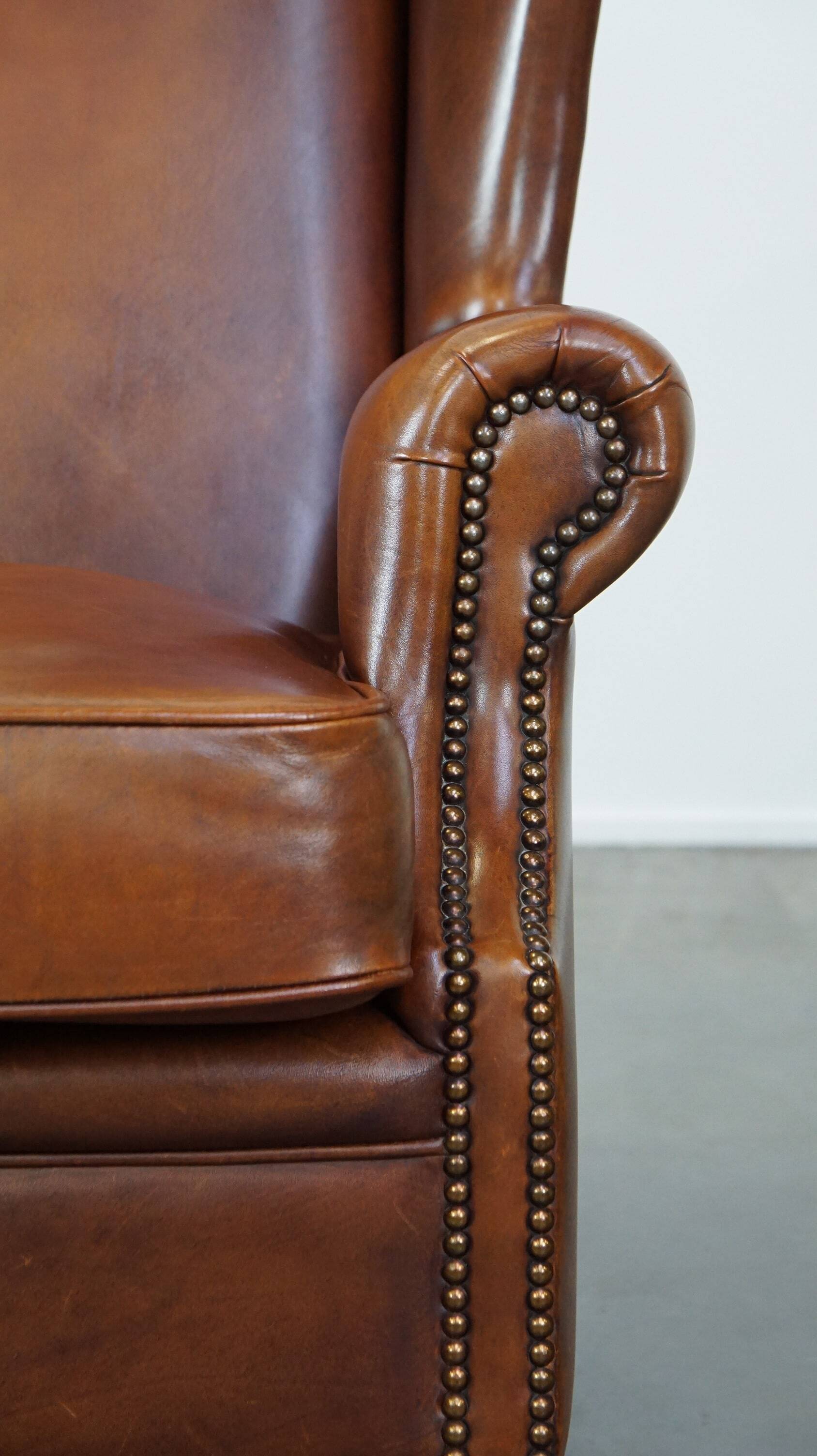 Fauteuil à oreilles en cuir de vachette cognac