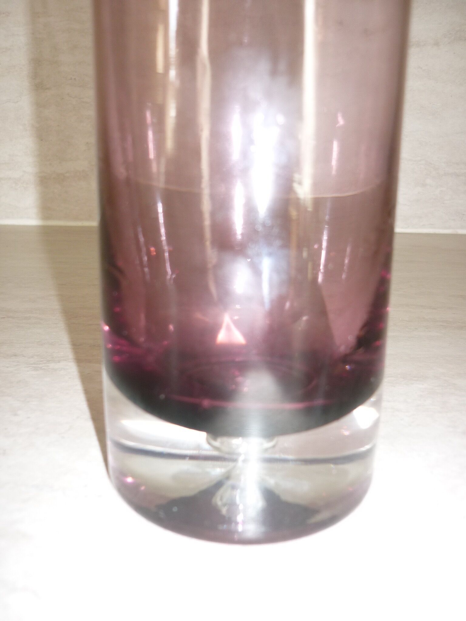 Plum-colored glass bottle with bubble